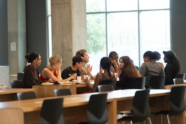 A group of students eating and talking.