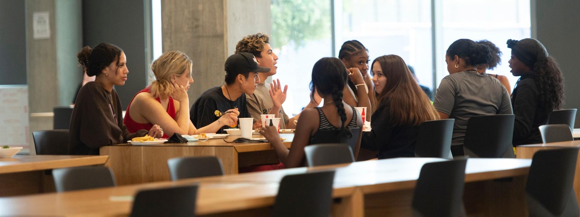 A group of students eating and talking.